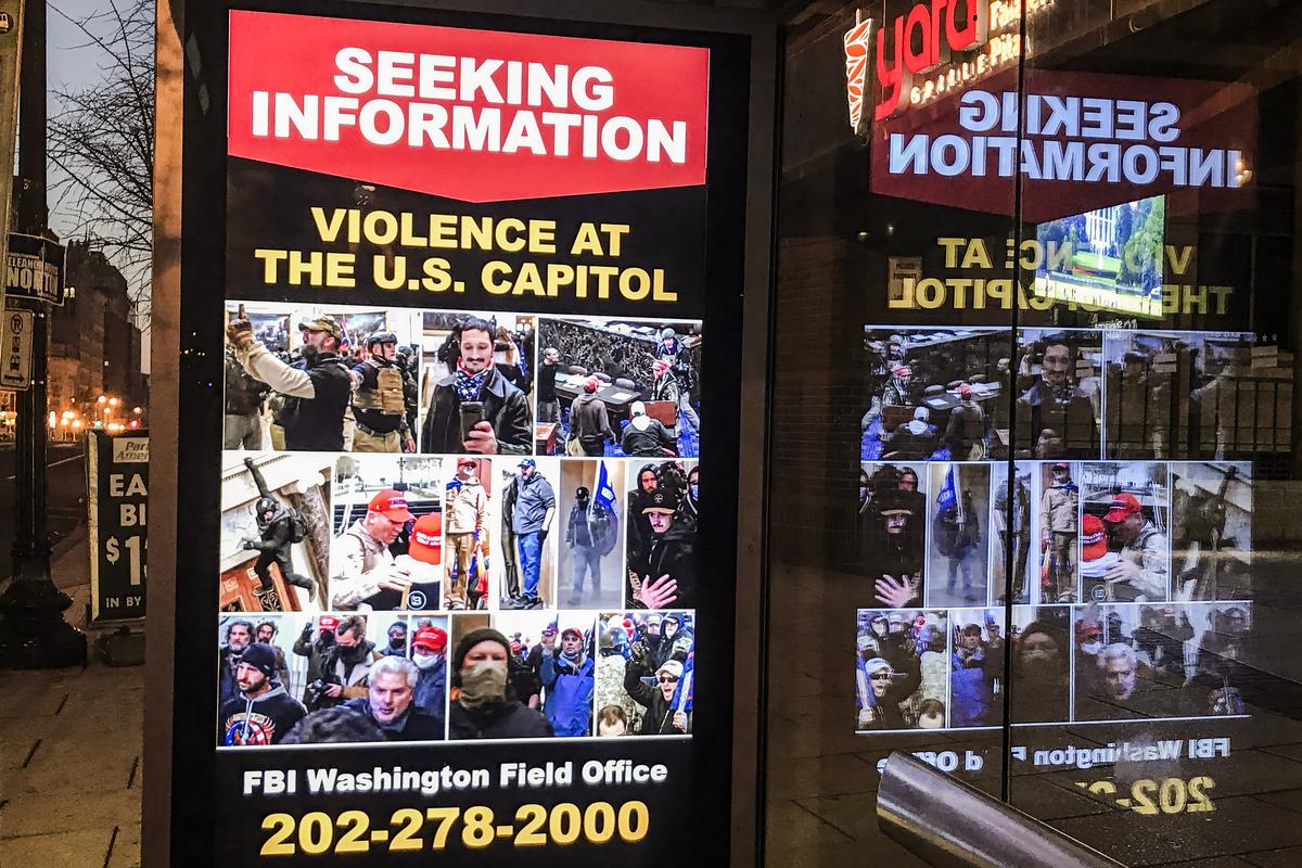 FBI manhunt information is displayed on the side of a bus stop in downtown Washington D.C. on Jan. 13, 2021. (Charlotte Cuthbertson/The Epoch Times)