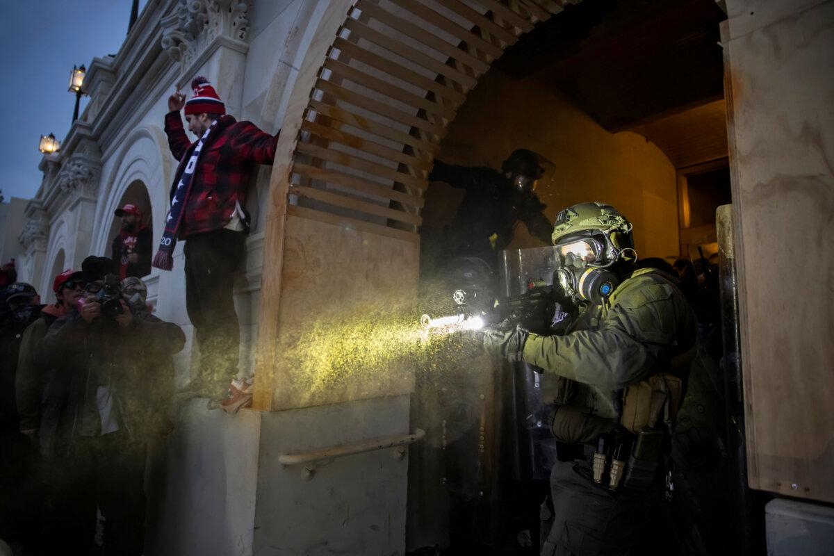 A Capitol Police officer fires what appears to be tear gas at protesters at the U.S. Capitol in Washington, on Jan. 6, 2021. (Brent Stirton/Getty Images)