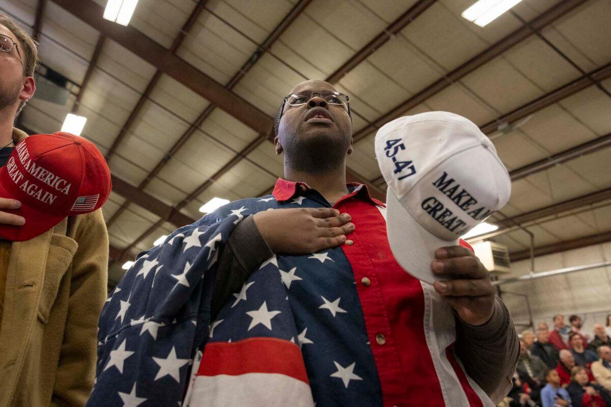 A supporter sings along to the national anthem prior to the arrival of former U.S. President and 2024 Republican presidential hopeful Donald Trump during a "Commit to Caucus" rally at the North Iowa Events Center in Mason City, Iowa, on Jan. 5, 2024. (Christian Monterrosa/AFP via Getty Images)