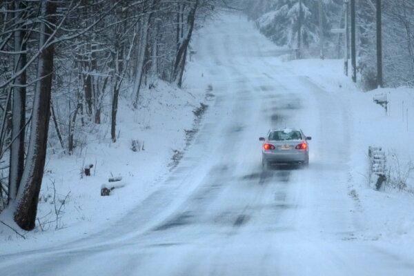 A car treks down a snow-covered road in Derry, N.H., on Jan. 7, 2024. (Charles Krupa/AP Photo)
