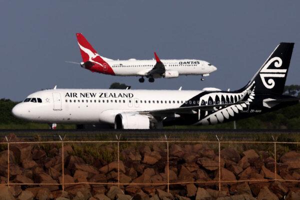 An Air New Zealand passenger aircraft in front of a landing Qantas Airways plane at Sydney's Kingsford Smith International Airport on Dec. 6, 2023. New Zealand's national carrier said on Dec. 6 that it aims to become the first airline to fly an electric plane after announcing plans to have a battery-powered aircraft join its fleet in 2026. (David Gray/AFP via Getty Images)