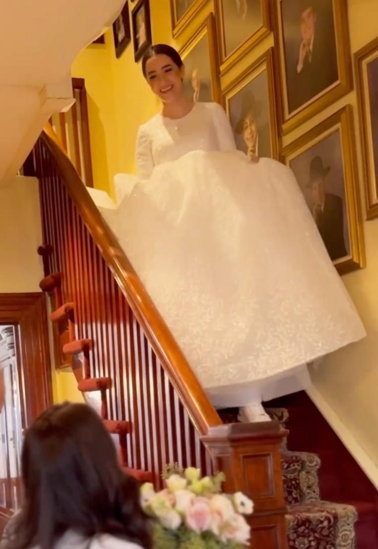 Hanna descends the stairs in her wedding dress to surprise her family. (Courtesy of Naftali Marasow)