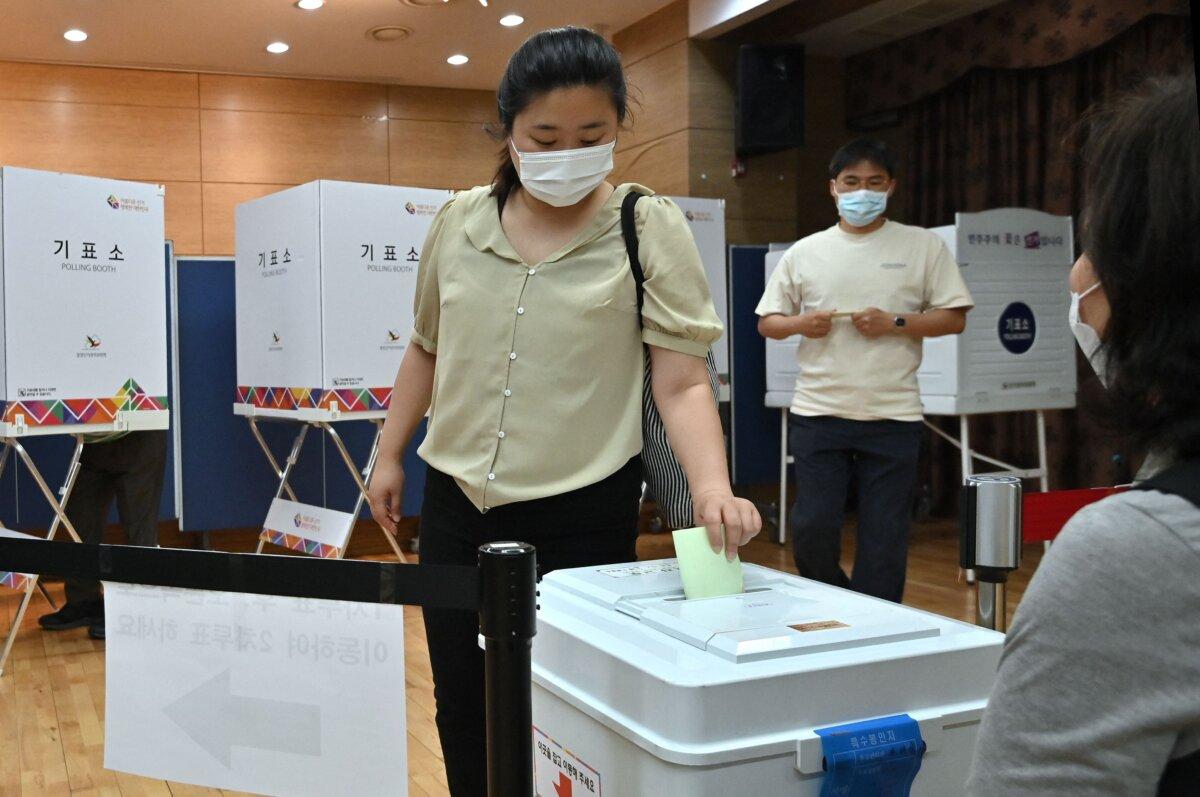 A woman casts her vote for nationwide local elections to elect mayors, governors, local council members, and regional education chiefs at a polling station in Seoul on June 1, 2022. (Jung Yeonje /AFP via Getty Images)