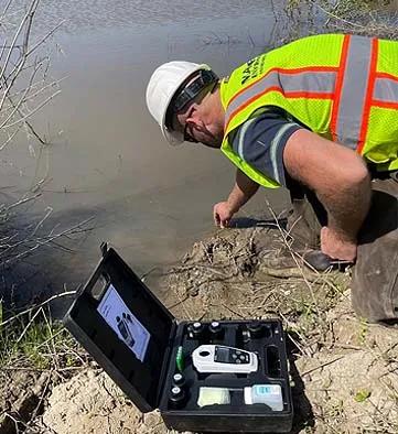 A stormwater manager performs water quality testing and erosion monitoring at a contaminated brownfield in California. ( Courtesy of Mayfield Environmental Engineering)