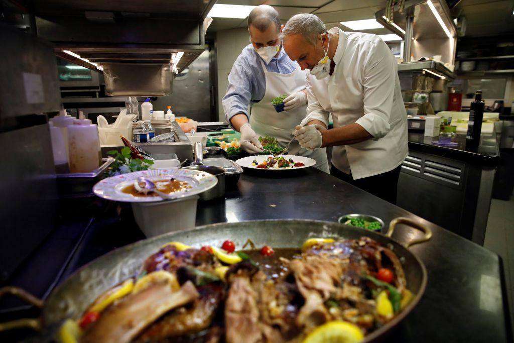 French three-star chef Christian Le Squer (R) and one-star chef Alan Taudon (L) cook for employees of a Parisian hospital in the kitchen of "Le Cinq" restaurant at the Four Season George V palace hotel in Paris, on April 11, 2020. (Thomas Coex/AFP via Getty Images)