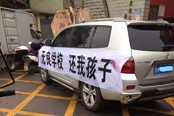 A van with a banner that reads “Unscrupulous School, Return My Child” is parked in front of Zhongshan Vocational School in China's Hunan Province in May 2023. (Courtesy of Li Zhu)