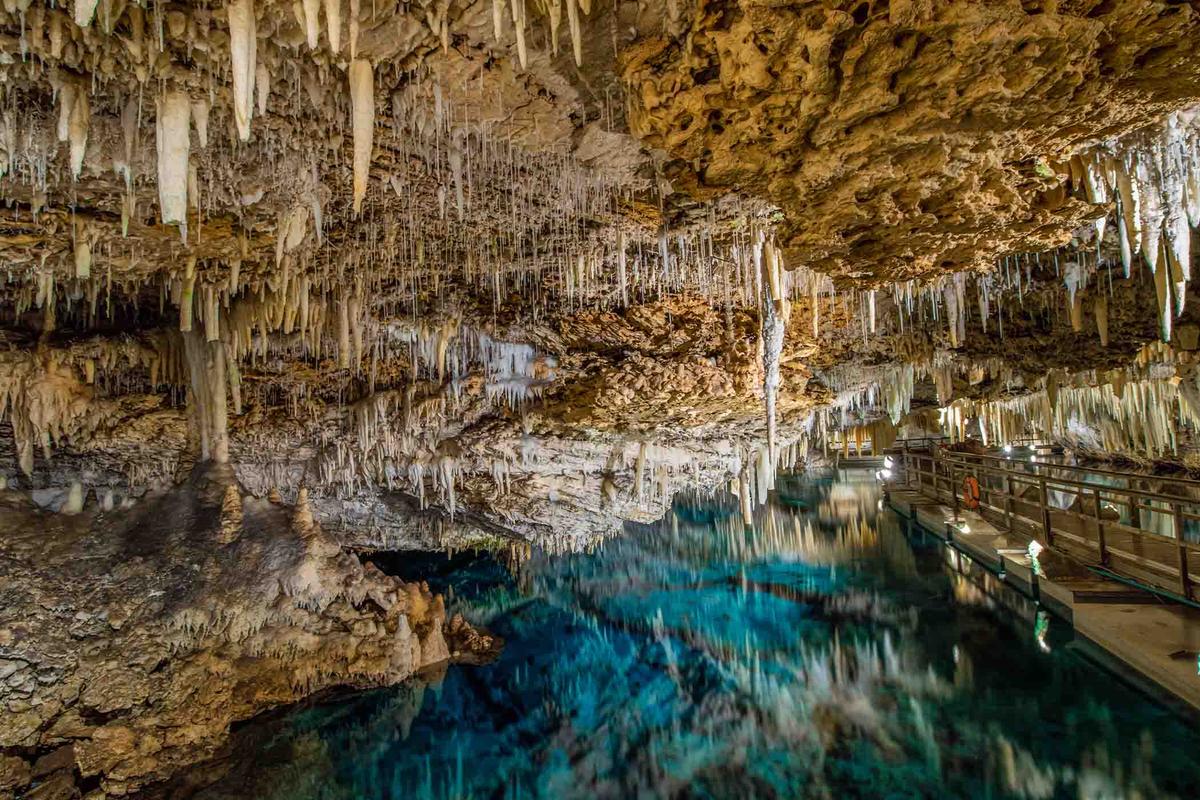 An unworldly scene of an underground lake with geological formations inside the Crystal Caves. (Scott Heaney/Shutterstock)
