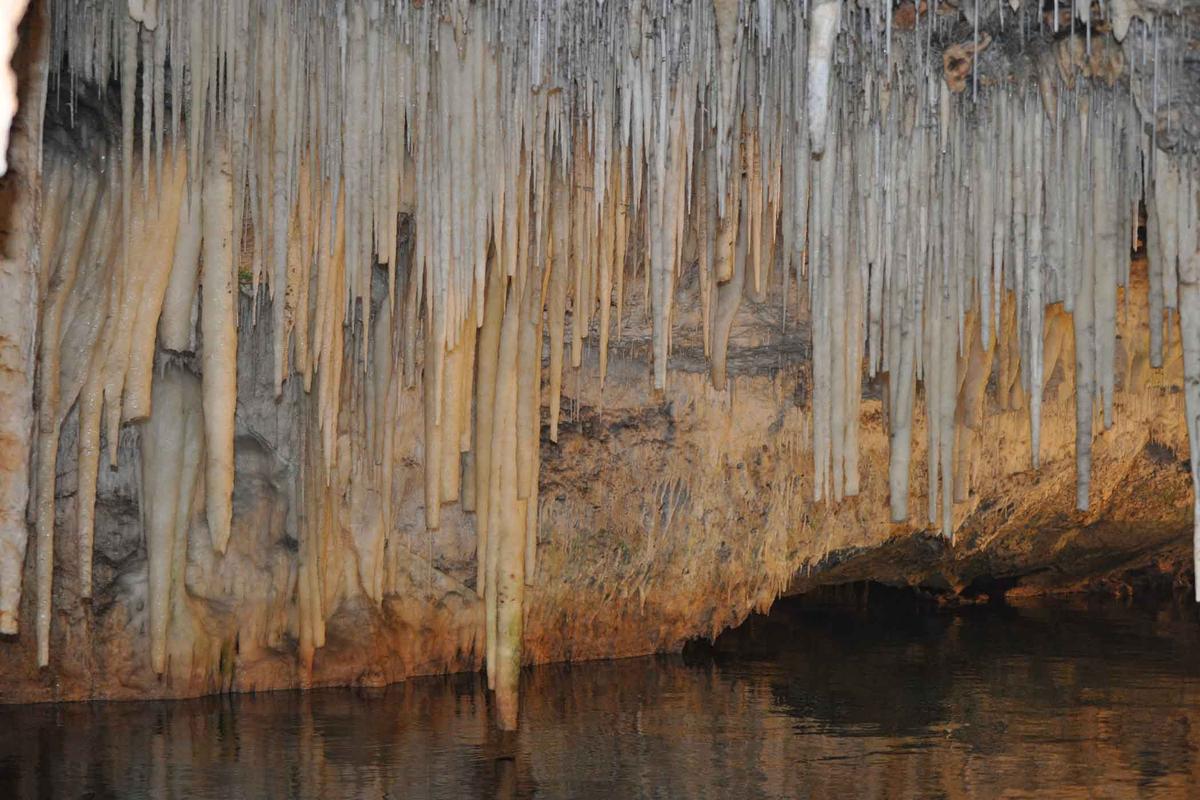 Crystal stalactites hanging over an underground lake. (GeographicVisions/Shutterstock)