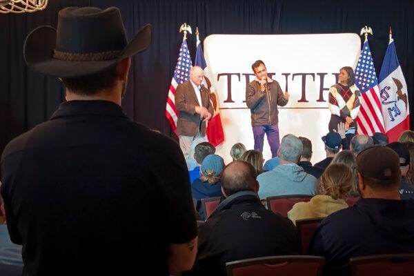 (L-R) A man in a cowboy hat watches Steve King, Vivek Ramaswamy, and Candace Owens at the National Czech-Slovak Museum & Library in Cedar Rapids, Iowa, on Jan. 11, 2024. (Nathan Worcester/The Epoch Times)