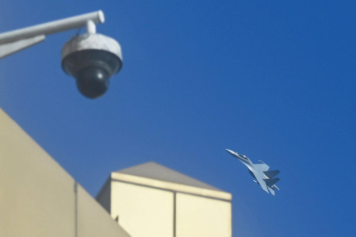 A Chinese jet fighter flies above a closed circuit television (CCTV) camera and buildings on Pingtan Island, the closest point in China to the main island of Taiwan, in China's southeast Fujian province, on Jan. 13, 2024, during Taiwan's presidential election. (Greg Baker/AFP via Getty Images)