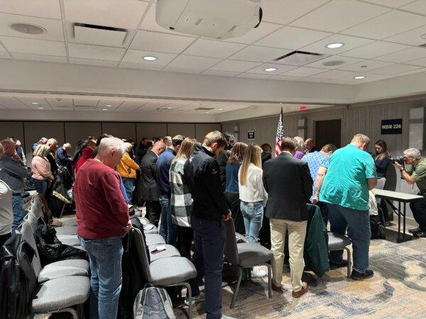 Voters at Precincts 226 and 227 in West Des Moines bow their heads in prayer ahead of the Iowa caucuses on Jan. 15, 2024. (Jackson Richman/The Epoch Times)