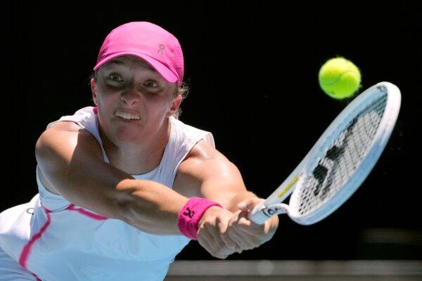 Iga Swiatek of Poland plays a backhand return to Sofia Kenin of the U.S. during their first round match at the Australian Open tennis championships at Melbourne Park, Melbourne, Australia, on Jan. 16, 2024. (Andy Wong/AP Photo)