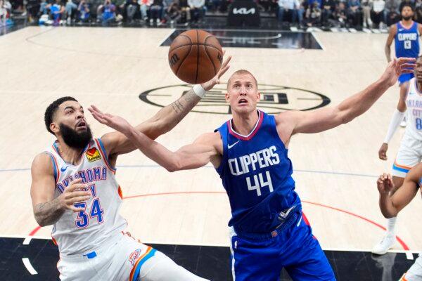 Oklahoma City Thunder forward Kenrich Williams (L) and Los Angeles Clippers center Mason Plumlee reach for a rebound during the first half of an NBA basketball game in Los Angeles on Jan. 16, 2024. (Mark J. Terrill/AP Photo)