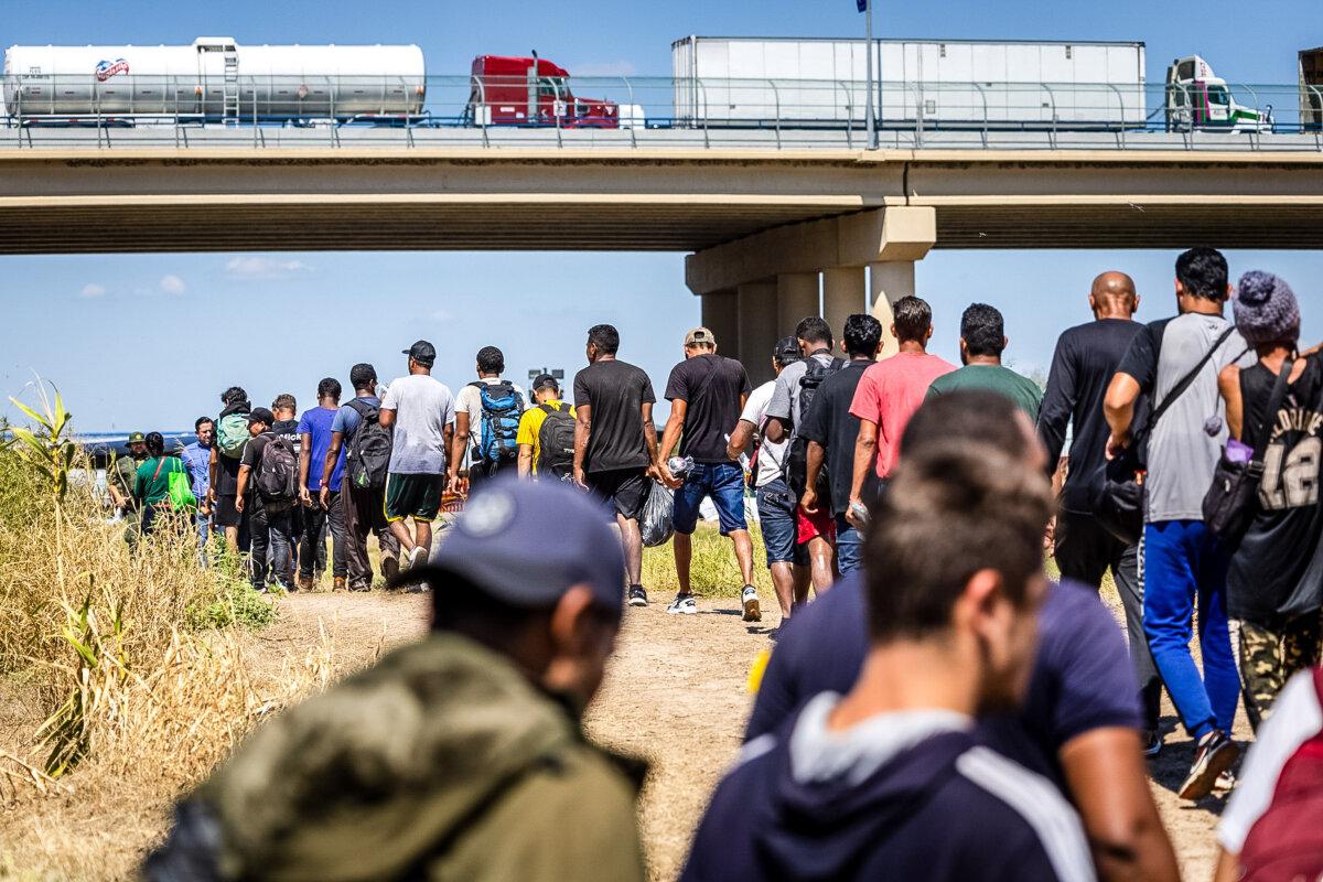 Illegal immigrants walk toward a U.S. Border Patrol checkpoint after crossing the U.S.-Mexico border in Eagle Pass, Texas, on Sept. 28, 2023. (John Moore/Getty Images)