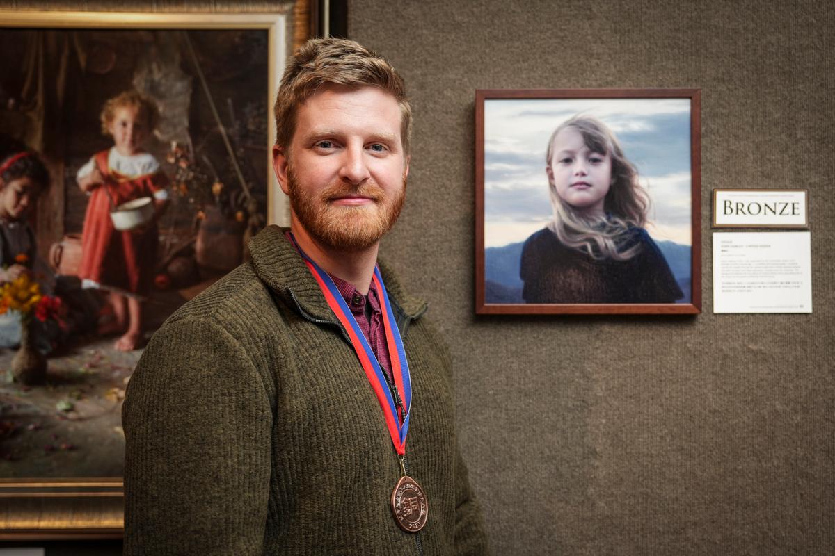 John Darley of the United States with his bronze award-winning portrait "Vivian." Mr. Darley's website states that he's inspired by the mastery of Michelangelo and the sentimental beauty of Bouguereau. (Samira Bouaou/The Epoch Times)