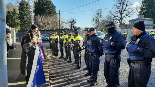 A group of police officers standing in front of Falun Gong demonstrators during Chinese Premier Li Qiang's visit, outside of Phoenix Park in Dublin, Ireland, on Jan. 17, 2024. (Irish Falun Dafa Association)