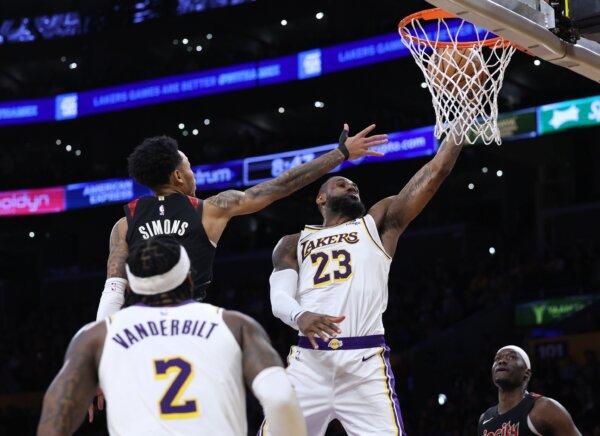 LeBron James (23) of the Los Angeles Lakers scores past Anfernee Simons (1) of the Portland during a win in Los Angeles on Jan. 21, 2024. (Harry How/Getty Images)