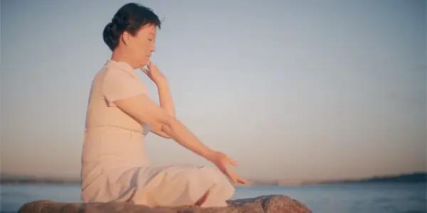 Michelle Zhang started to practice Falun Gong after her sister's disappearance. Here, she is doing a Falun Gong exercise, from a still of the 2024 documentary "State Organs." (RooYee Films)