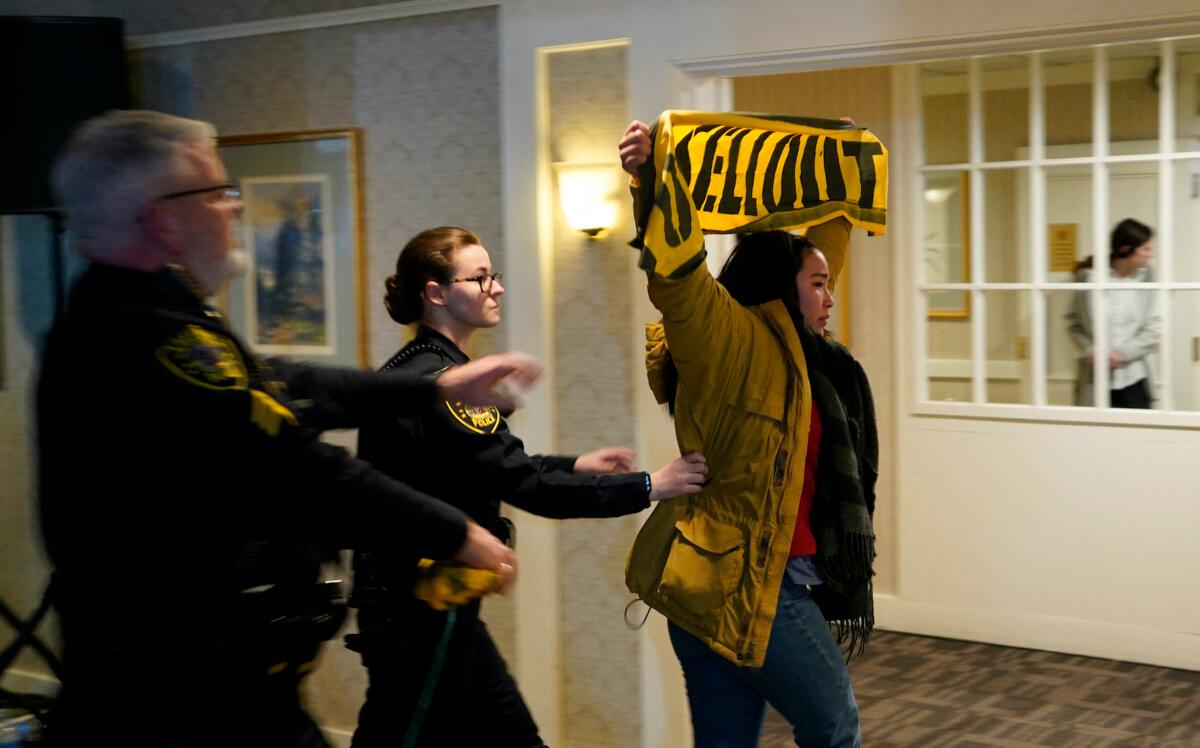 A protestor is led out by police as Republican presidential hopeful and former U.S. President Donald Trump holds a rally in Laconia, N.H., on Jan. 22, 2024. (Timothy A. Clary/AFP via Getty Images)