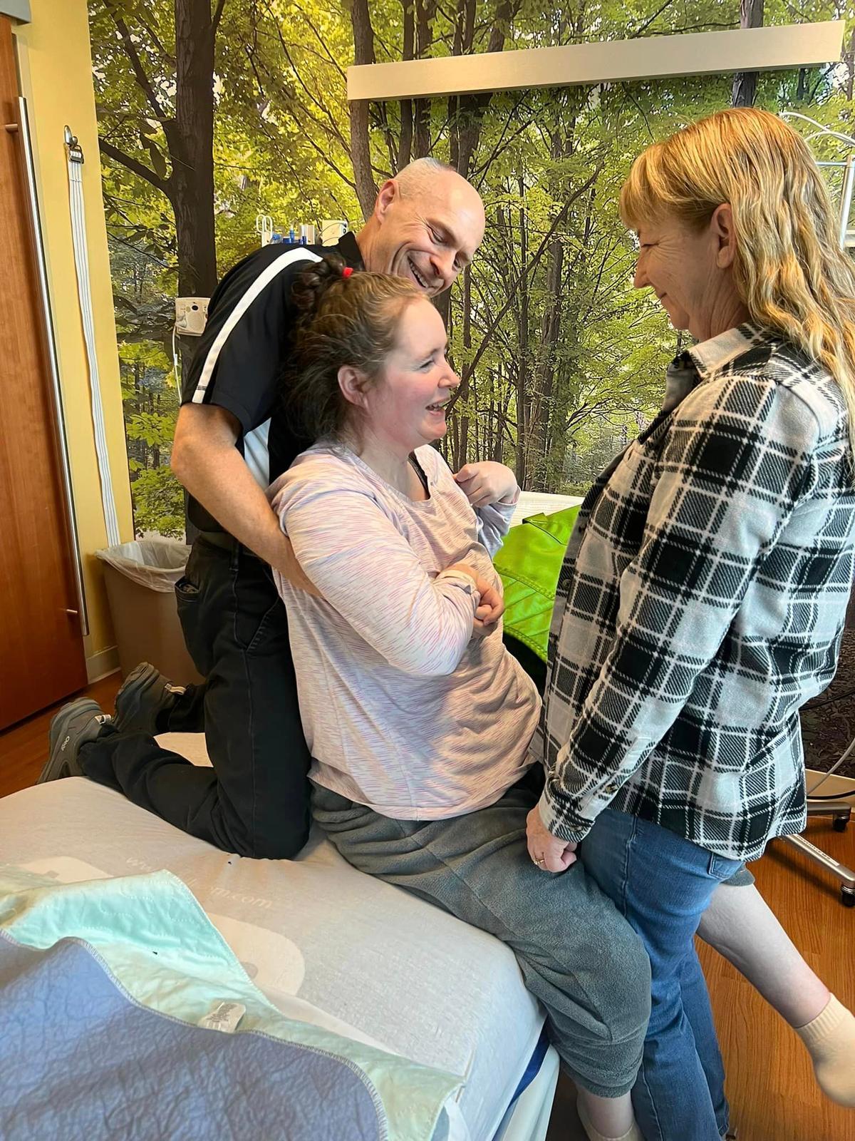 (L-R): A therapist at Mary Free Bed, Ms. Flewellen receiving therapy, and her mom, Ms. Means. (Courtesy of <a href="https://www.facebook.com/profile.php?id=61554133355459">Jenn’s Journey: A Miracle in the Making</a>)