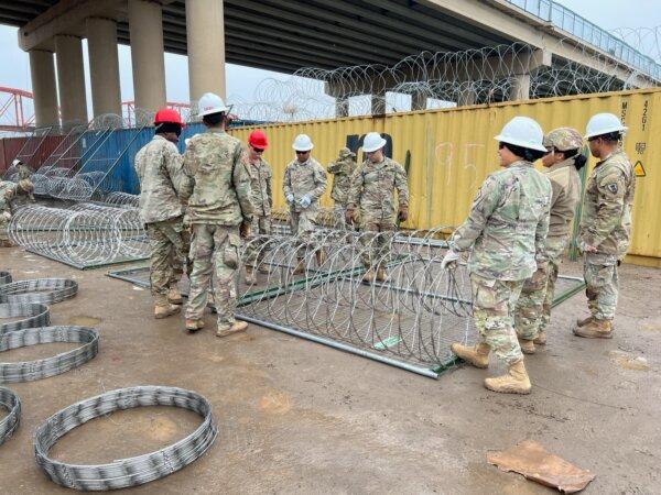Texas National Guard members place barriers at Shelby Park, on the U.S.–Mexico border, in Eagle Pass, Texas, on Jan. 23, 2024. (Charlotte Cuthbertson/The Epoch Times)