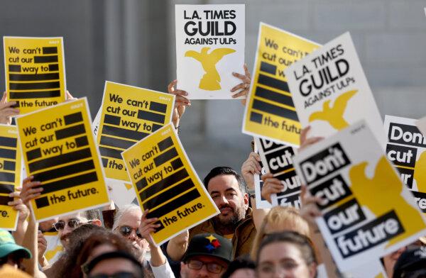 Los Angeles Times Guild members hold up signs during a rally outside City Hall against ‘significant’ imminent layoffs at the Los Angeles Times newspaper during a one-day walkout in Los Angeles on Jan. 19, 2024. (Mario Tama/Getty Images)