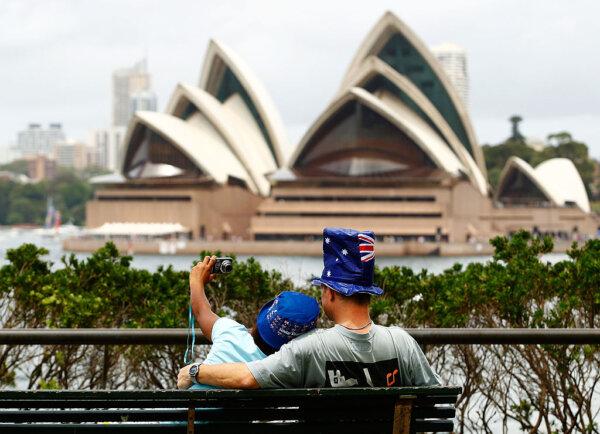 A couple takes photos in front of Sydney's Opera House as part of celebrations for Australia Day In Sydney, on Jan. 26, 2012. (Brendon Thorne/Getty Images)