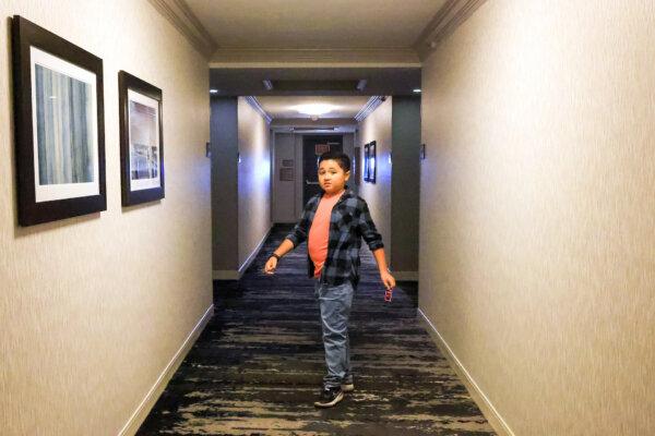 Eli German, center, a 10-year-old boy with autism, walks in a hallway at the Hilton Hotel in Concord, Calif., on Friday, Jan. 5, 2024. German and his family of five have stayed in the hotel free of charge through the Concord’s Practice Stay program, which serves traveling families with a loved one diagnosed with Autism Spectrum Disorders. (Ray Chavez/Bay Area News Group)