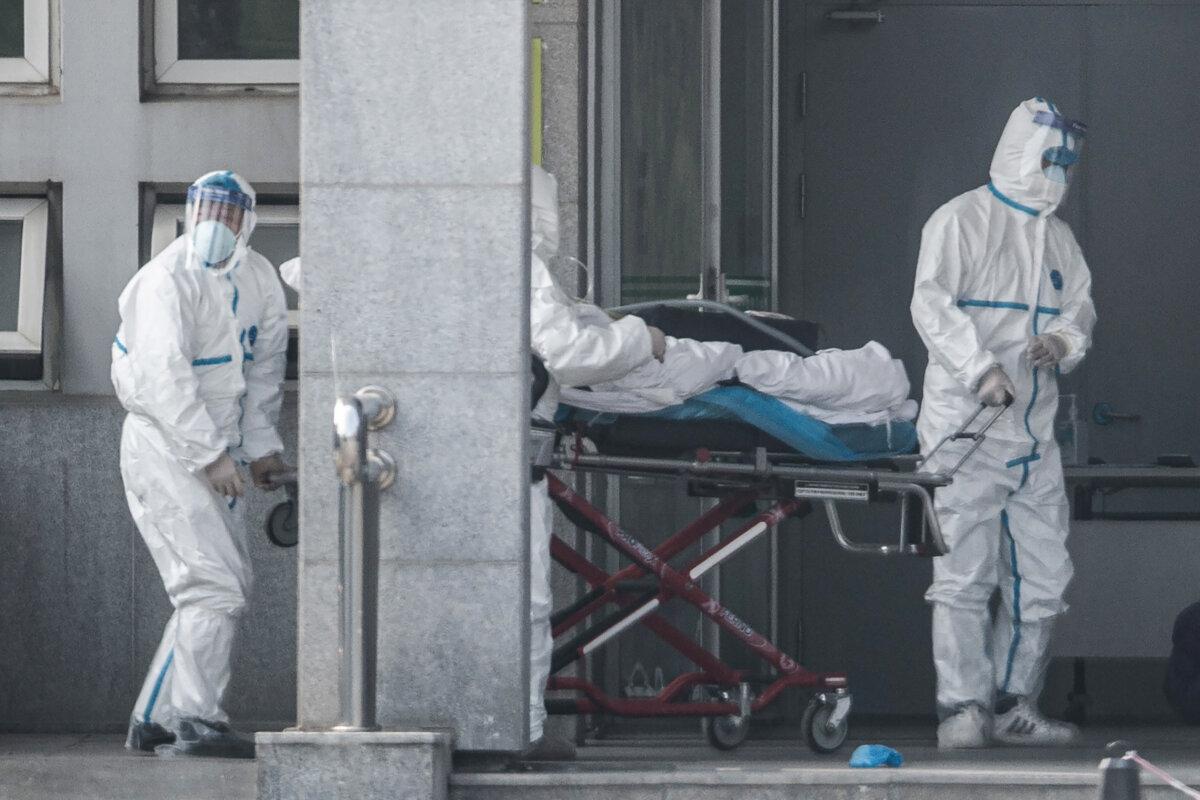 Medical staff members carry a patient into Jinyintan hospital, where patients infected by a mysterious SARS-like virus were being treated, in Wuhan, Hubei Province, China, on Jan. 18, 2020. (STR/AFP via Getty Images)