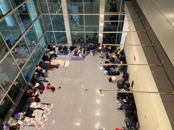 Illegal immigrants sheltering in a public wing at Boston’s Logan Airport. (Alice Giordano/The Epoch Times)