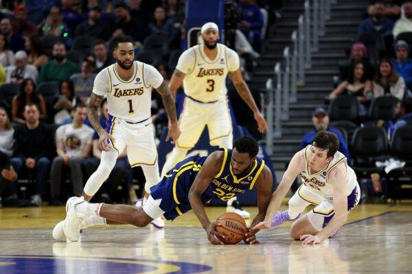 Andrew Wiggins (22) of the Golden State Warriors and Austin Reaves (15) of the Los Angeles Lakers go for a loose ball at Chase Center in San Francisco on Jan. 27, 2024. (Ezra Shaw/Getty Images)