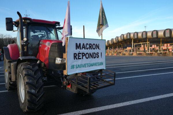 A tractor bears a placard which reads "Macron, answer! #saveyoufarmer" a protesting farmers blockade the A10 autoroute during a protest against taxation and declining income, near the Peage de Saint-Arnoult-en-Yvelines toll gates southwest of Paris, on Jan. 26, 2024, as part of a nationwide day of protests called by several farmers unions on pay, tax and regulations. (Dimitar DILKOFF/AFP)
