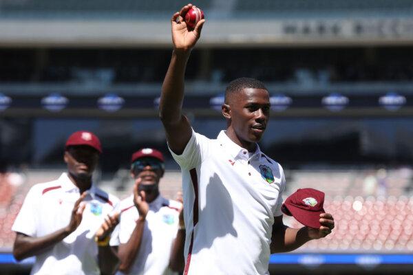 Shamar Joseph of the West Indies holds the ball aloft while walking from the field after taking 5 wickets in the first innings during day two of the First Test in the Mens Test match series between Australia and West Indies at Adelaide Oval in Australia, on Jan. 18, 2024. (Paul Kane/Getty Images)