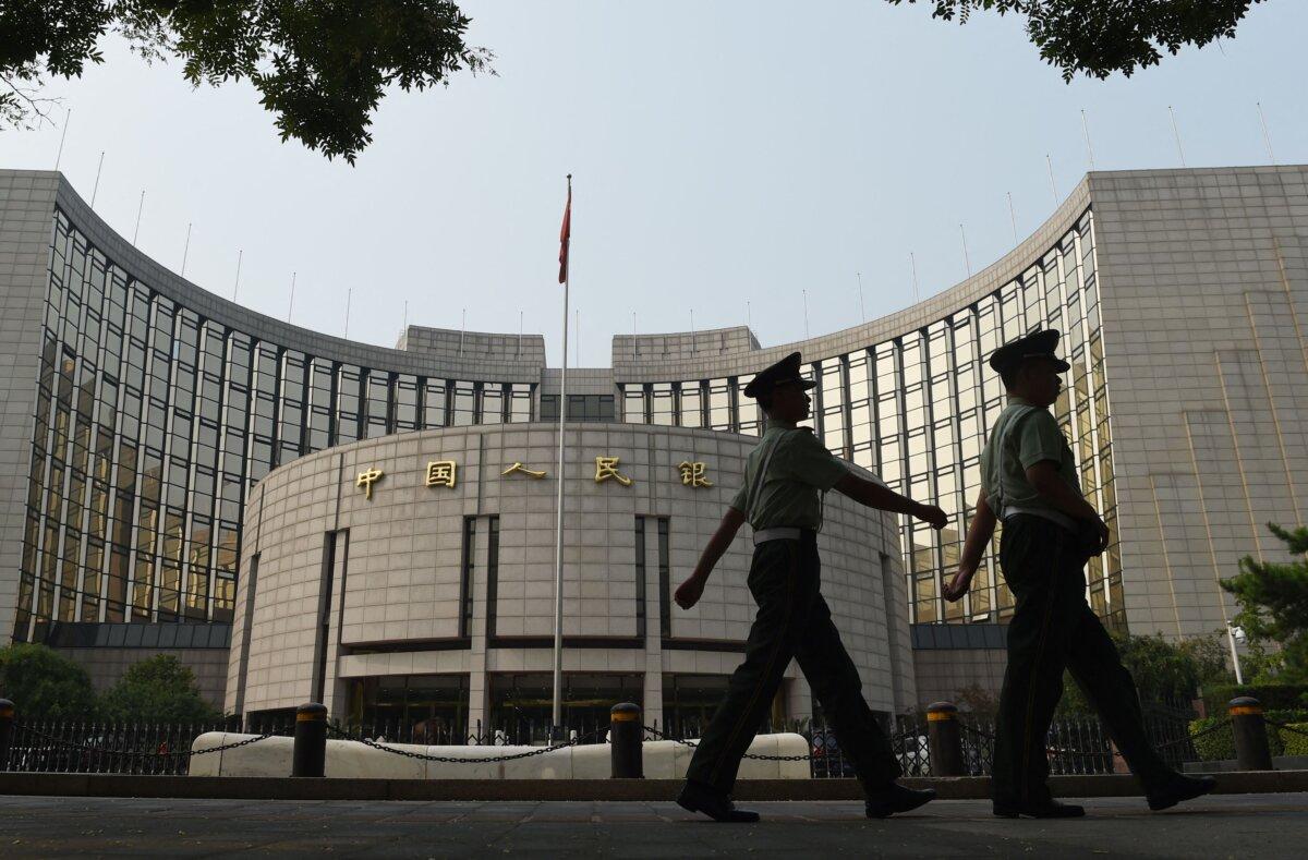 Paramilitary policemen patrol in front of the People's Bank of China, the central bank of China, in Beijing on July 8, 2015. (Greg Baker/AFP via Getty Images)