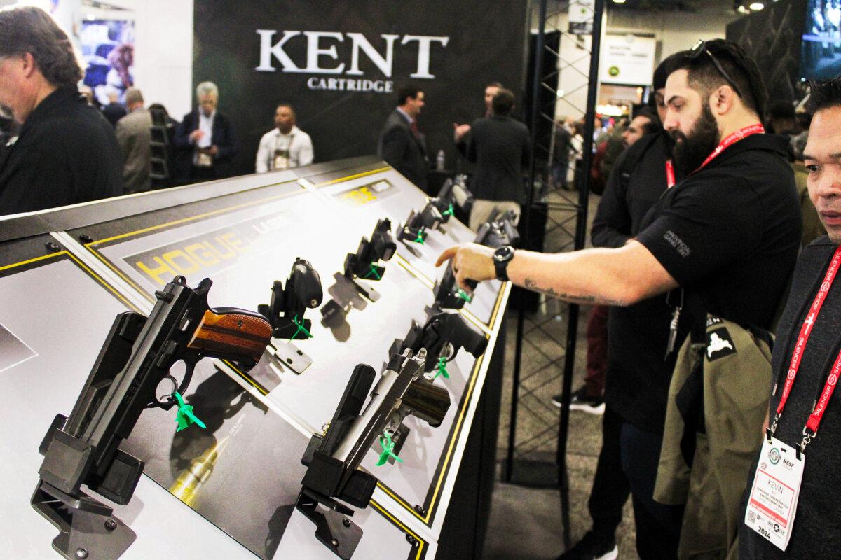 Attendees check out pistols on display at the Shooting, Hunting, Outdoors Trade (SHOT) Show, on Jan. 23, 2024, in Las Vegas, Nevada. (Michael Clements/The Epoch Times)