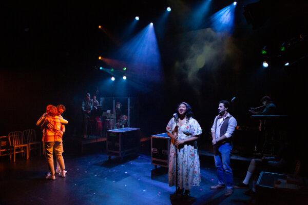(L–R) Wolf Man (Kristoffer Cusick) and Mother Dearest (Erika Rolfsrud) hug, while singer Hannah-Kathryn Wall and Narrator Joél Acosta give musical accompaniment to the scene. (Hunter Canning)
