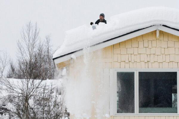 A man uses a shovel to remove snow from his roof, in Anchorage, Alaska on Jan. 29, 2024. (Mark Thiessen/AP Photo)