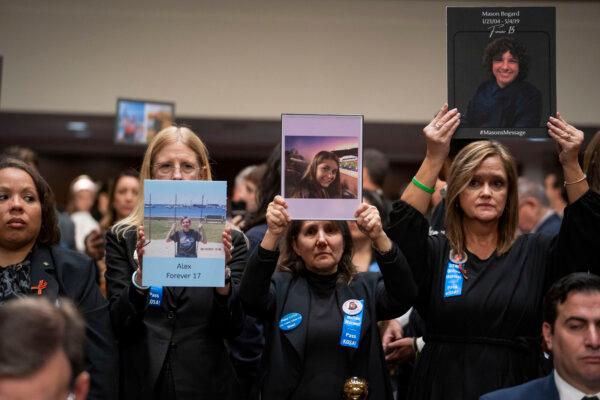 Parents hold photos of children who passed away ahead of the social media CEO’s testimony about big tech and the online child sexual exploitation crisis before the Senate Judiciary Committee in Washington on Jan. 31, 2024. (Madalina Vasiliu/The Epoch Times)