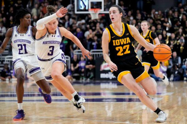 Iowa guard Caitlin Clark (22) narrowly avoided injury Jan. 21, when fans in Columbus, Ohio, raced onto the court. Above, Clark drives past Northwestern guard Maggie Pina during a game in Evanston, Ill., on Jan. 31, 2024. (Nam Y. Huh/AP Photo)