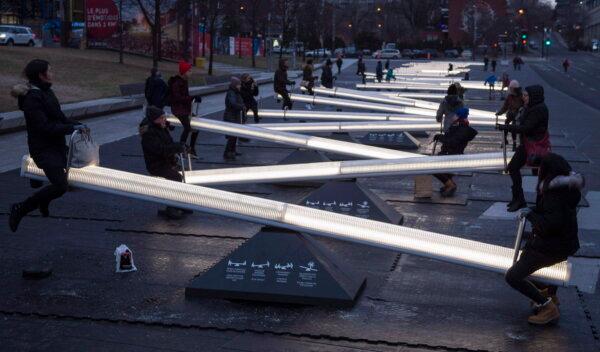 People play on a series of 30 interactive seesaws with light and sound as part of the Montreal en Lumiere mid-winter festival in 2017. (The Canadian Press/Paul Chiasson)