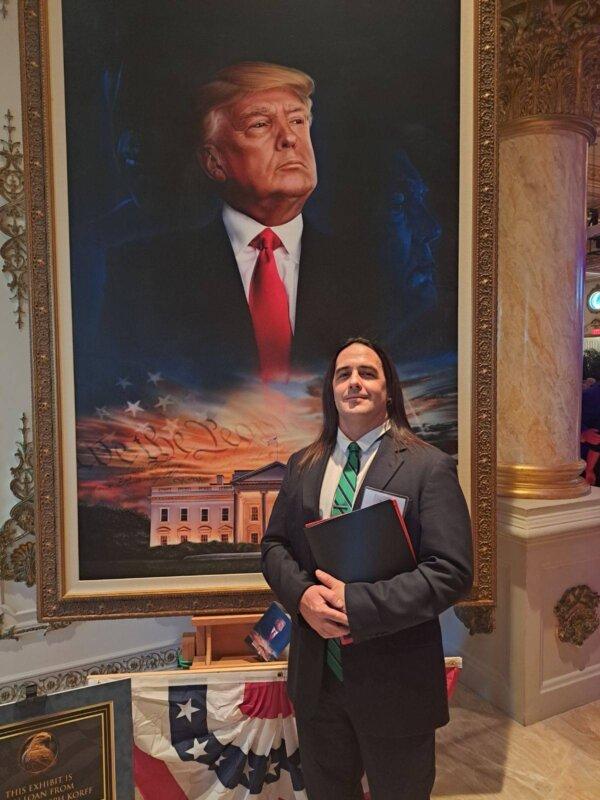 Paul Hodgkins stands before a portrait of President Donald Trump at the Lincoln Day Dinner at Mar-A-Lago in Palm Beach, Florida, on March 17, 2023 (Courtesy of Paul Hodgkins).
