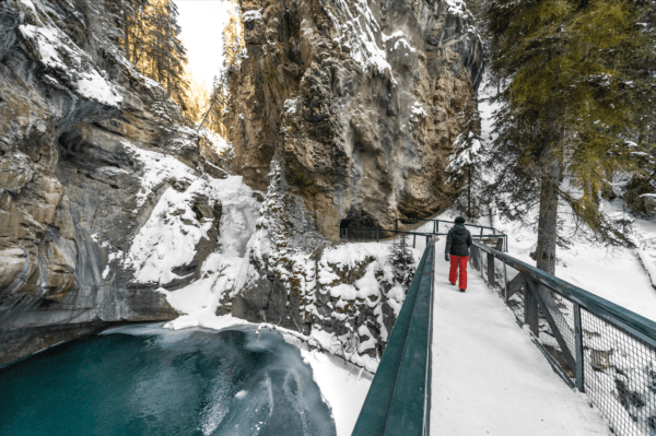 A visitor takes a winter hike on the Lower Falls trail of Johnston Canyon. (Photo by Marck Gutt/ don-viajes.com)