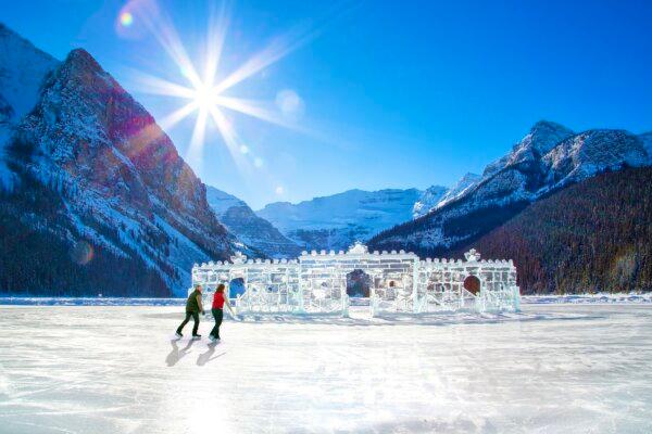 A couple skates on a frozen Lake Louise toward the winter ice castle. Skating is a favourite pastime for winter visitors. (Photo by Fairmont Chateau Lake Louise)