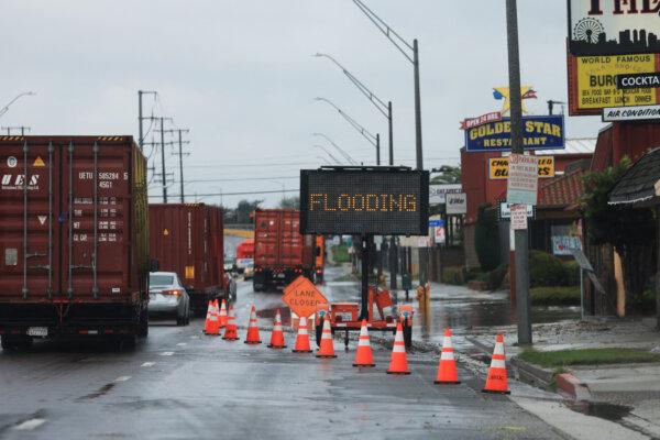 Flooding signs are placed by a road during a rain storm in Long Beach, Calif., on Feb. 1, 2024. (David Swanson/AFP via Getty Images)