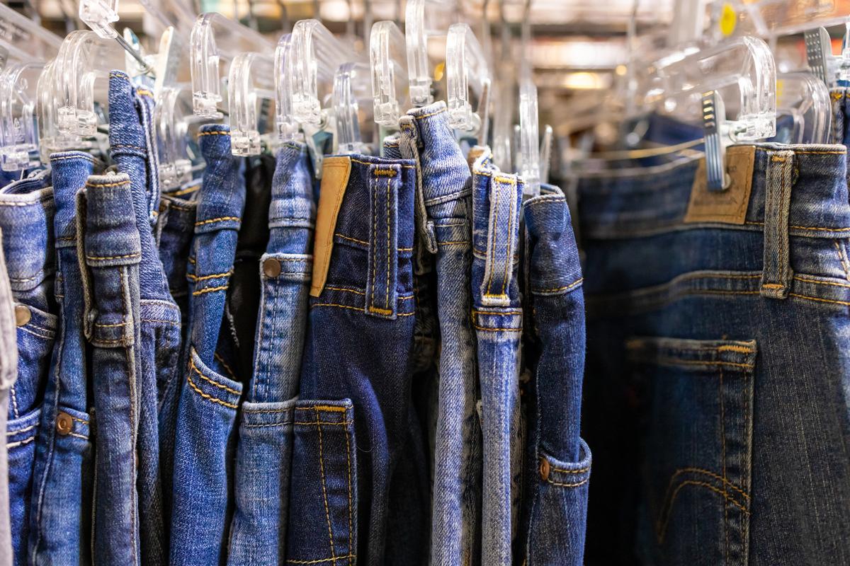 A rack of vintage jeans at an antique flea market. (Catherine McQueen/Moment/Getty Images)
