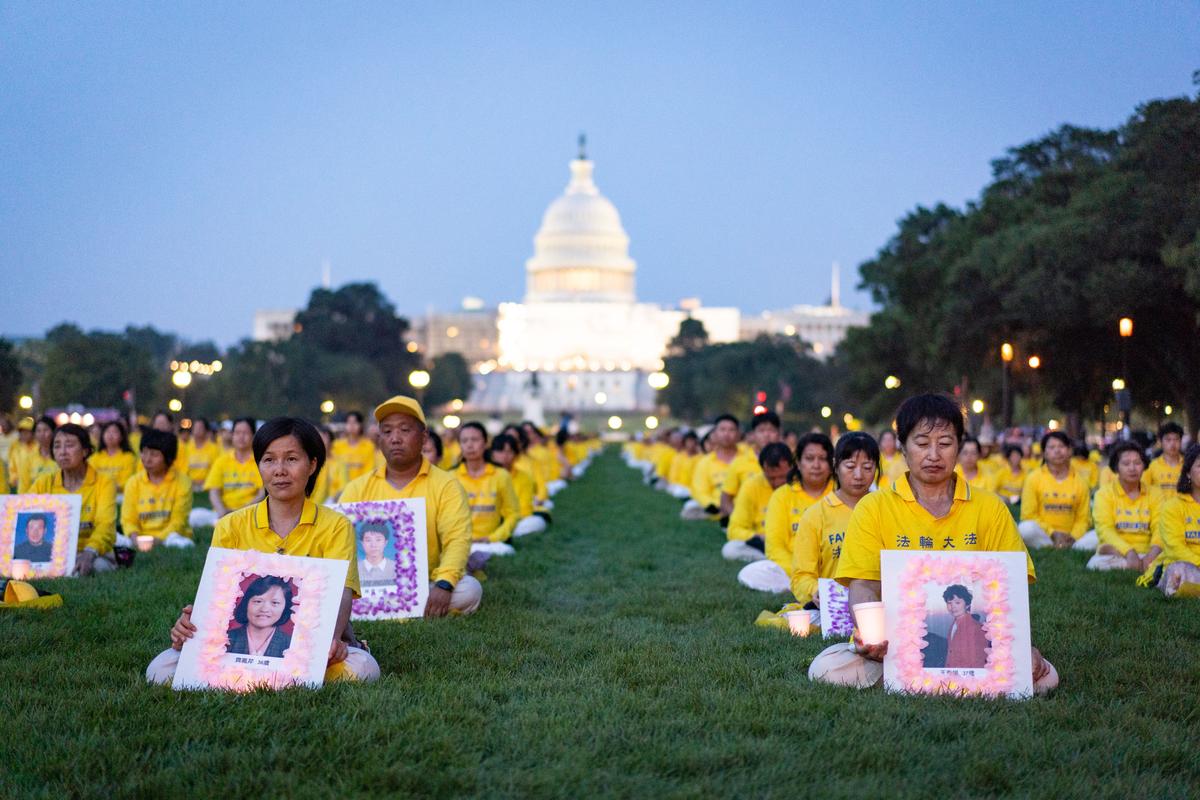 Falun Gong adherents take part in a candlelight vigil in memory of Falun Gong practitioners who passed away due to the Chinese Communist Party’s 24 years of persecution, at the National Mall in Washington on July 20, 2023. (Samira Bouaou/The Epoch Times)