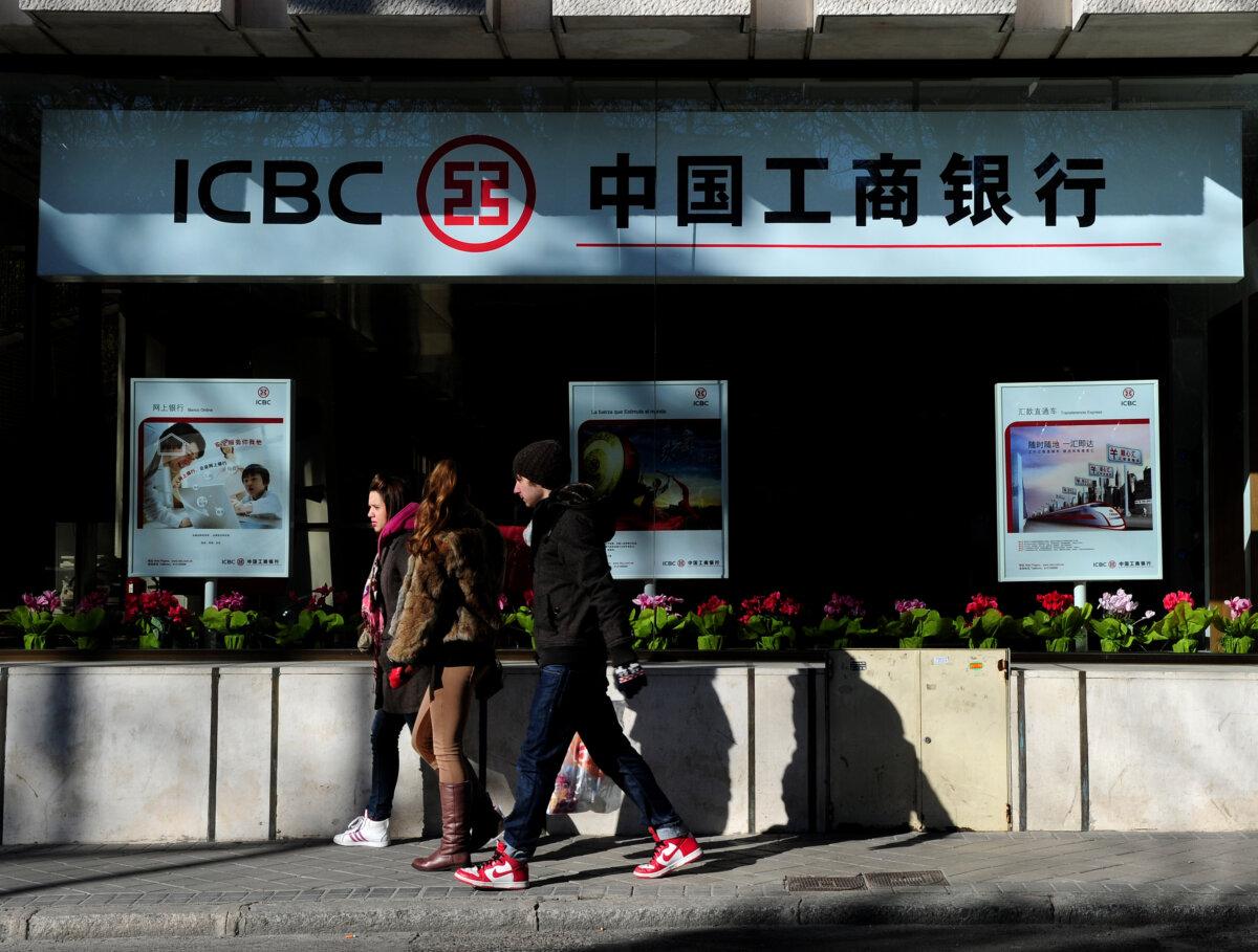Pedestrians stroll by a newly opened branch of the Industrial and Commercial Bank of China, in Madrid, Spain, on Jan. 25, 2011. (Jasper Juinen/Getty Images)