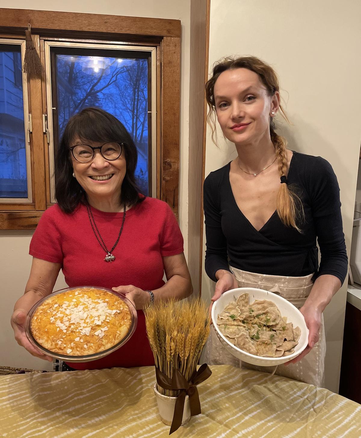 The author (L) and her neighbor Oleksandra showcase their bibingka and varenyky dishes. (Courtesy of Cherry Dumaual)