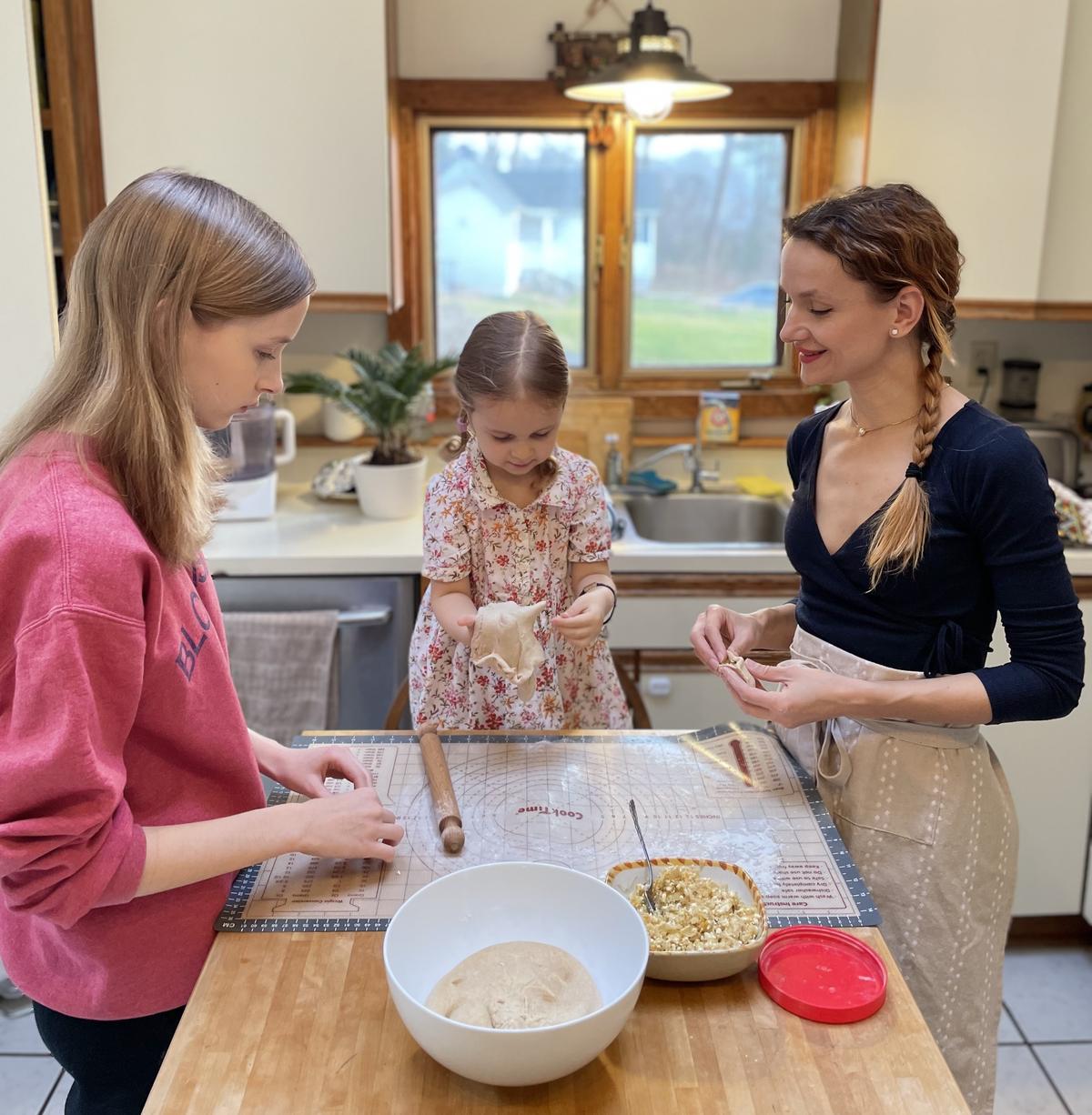 Oleksandra (R) and her daughters, Sofiya (L) and Zlata (C), make varenyky dough. (Courtesy of Cherry Dumaual)
