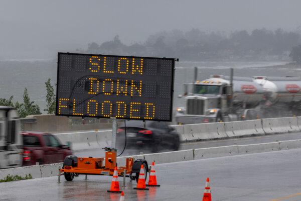 Signage in a road construction area on the 101 freeway warns of flooding as the second and more powerful of two atmospheric river storms, arrives south of Santa Barbara, Calif., on Feb. 4, 2024. (Davis McNew/AFP via Getty Images)